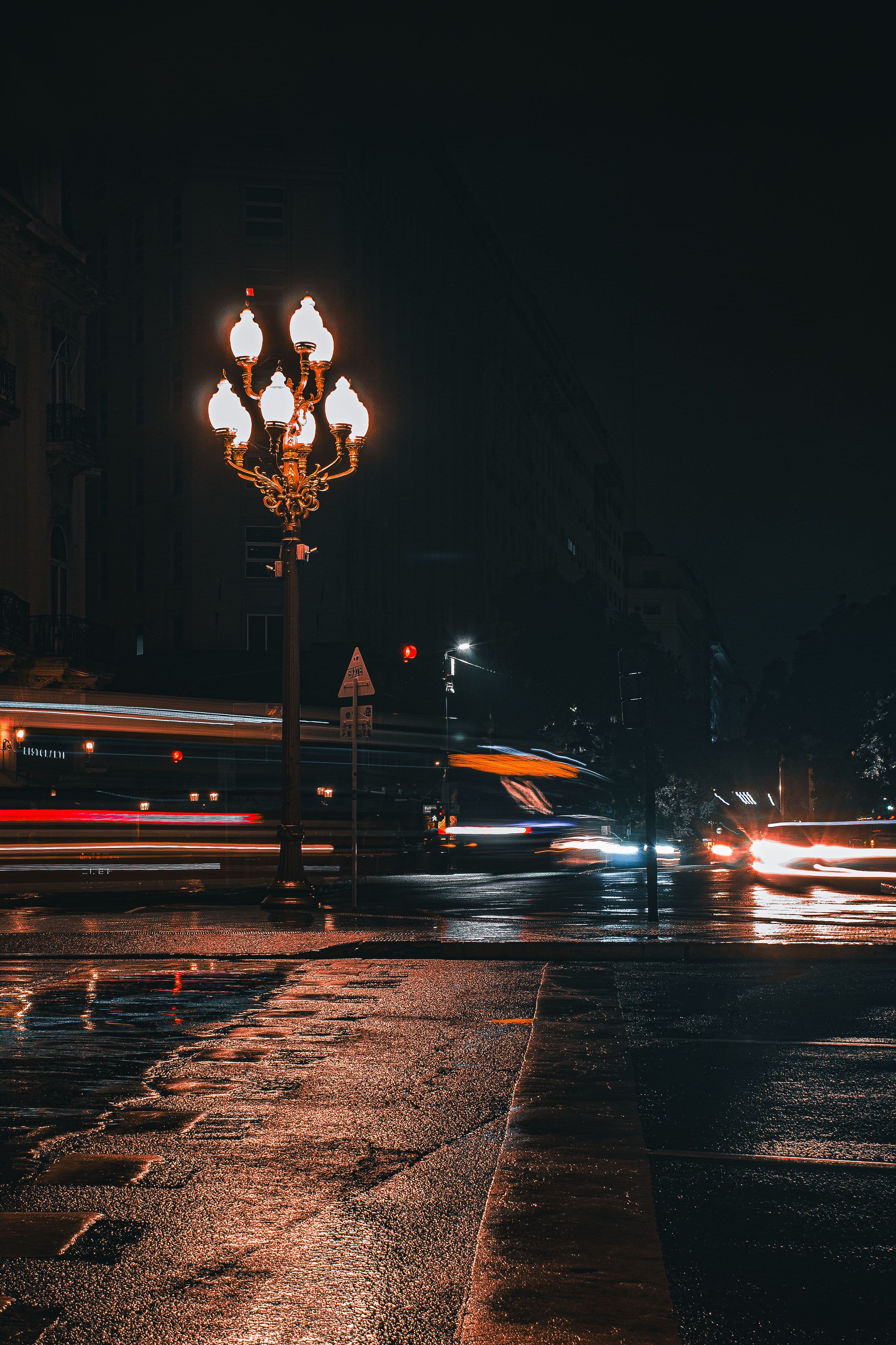 Car lights moving through a wet street in Buenos Aires at night